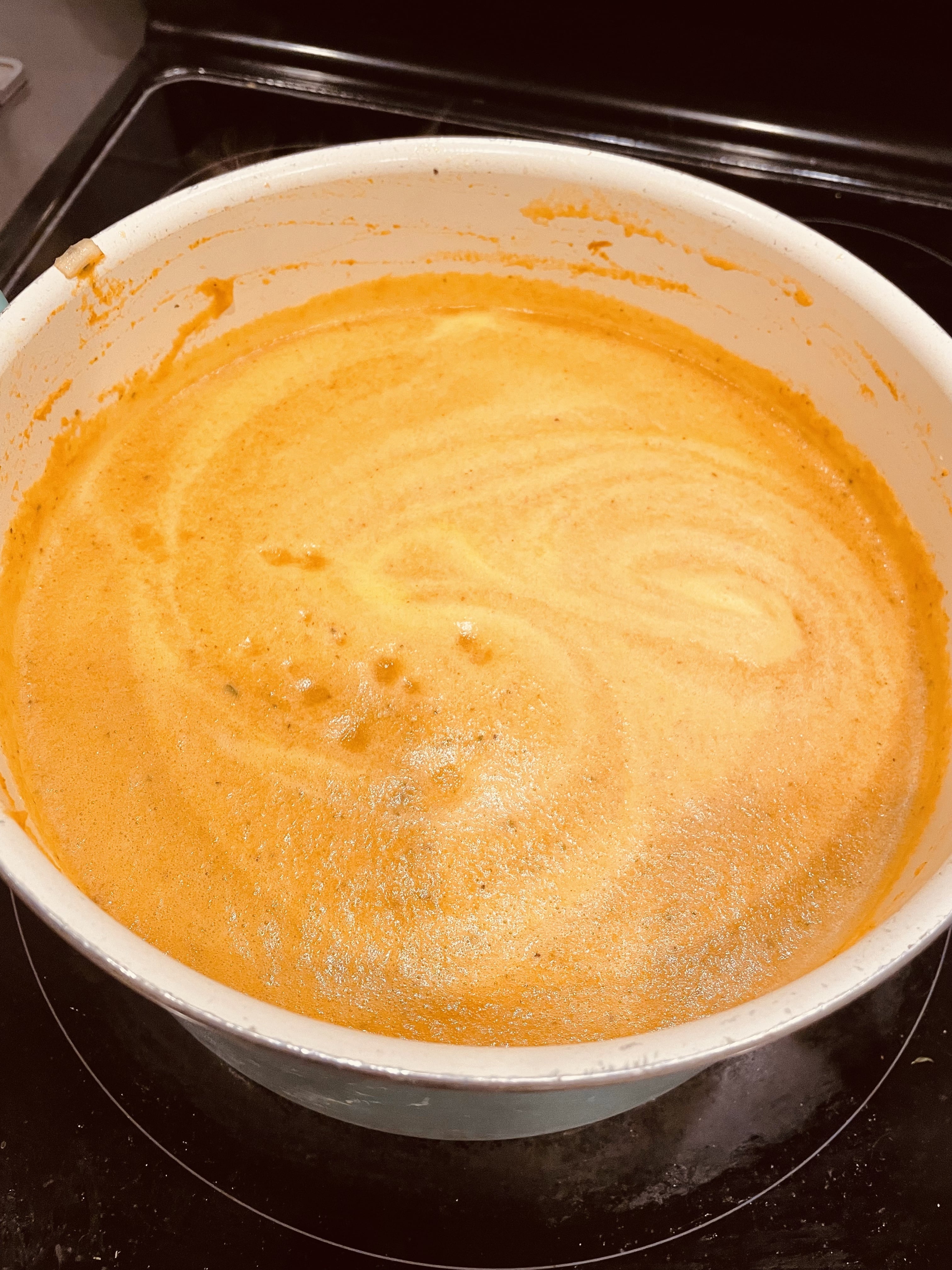 The soup before simmering is a lighter, almost creamy orange – after an hour or more of cooking, it will become a deeper, more rust-toned orange.