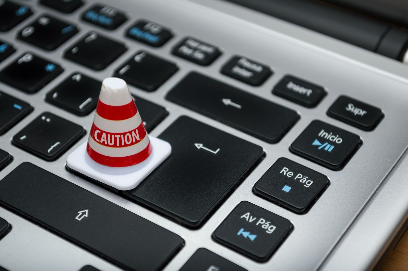 A traffic cone next to the delete button on a keyboard.